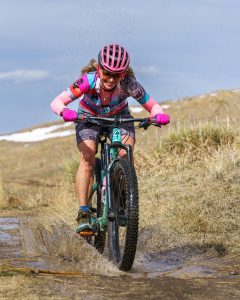 Dr. Sonja Stilp Mountain Biking tgrough a puddle